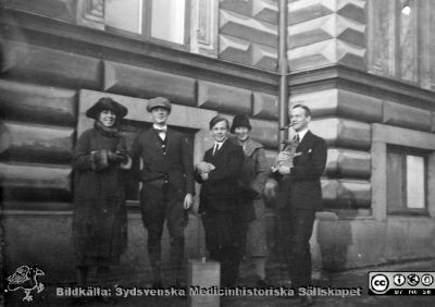 Album från histologikursen höstterminen 1925 i Lund
Album från histologikursen höstterminen 1925 i Lund. Bildtext: "Falk, Öster, fr. Sommarin, Ahlström."  Rimligen lärare på histologikursen. Ahlström kan vara C. G. Ahlström (1905-1990), senare professor i patologi i Lund. Han håller i en kanin. Kanske håller kand. Öster i en vit laboratorieråtta. Foto utanför anatomiska institutionen på Biskopsgatan 7. Bildkälla Locus Medicus Lundensis 2025-03-17. Fotograf okänd.
Nyckelord: Läarare;Amanuenser;Histologiska avdelningen;Anatomiska Institutionen;Sydsvenska Medicinhistoriska Sällskapet;Medicinska fakulteten;Locus Medicus Lundensis;Lunds