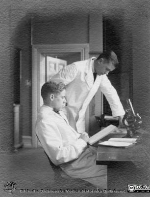 Fotoalbum tillägnat Professor Torsten Hellman från lärjungar under Kursen 1924 - 25
Fotoalbum tillägnat Professor Torsten Hellman från lärjungar under Kursen 1924 - 25. Två män i laboratorierockar vid ett mikroskop. Troligen kursamanuenser. De är inte identifierade.   Ingen bildtext.
Bildkälla Stiftelsen Locus Medicus Lundensis 250317. Fotograf okänd.
Nyckelord: Histologiska avdelningen;Anatomiska Institutionen;Medicinska fakulteten i Lund;Sydsvenska Medicinhistoriska Sällskapet;Locus Medicus Lundensis;Lärare