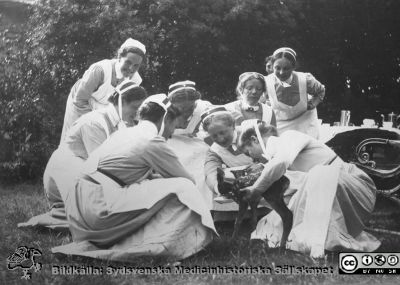 Sjuksköterskor i en park tillsammans med ett rådjurskid? 
Bild 19 i husmor Anna Landelius (1880-1964) efterlämnade fotoalbum. Ingrid Frennhoff (f. 1944) hade övertagit detta album efter sin morfar som i sin tur tagit hand om det efter sin syster husmor Anna på Lasarettet i Lund. Gåva till Sydsvenska Medicinhistoriska Sällskapet nyåret 2020.- Möjligen i sjukhusparken i Orup, där man en tid hade en liten djurpark. Flera av sjuksköterskonra bär SSSH-mössor med hakband och broscher.
Nyckelord: Sjukhuspark;Sjuksköterska;Södra Sveriges Sjuksköterskehem;SSSH;Rådjur;Orup