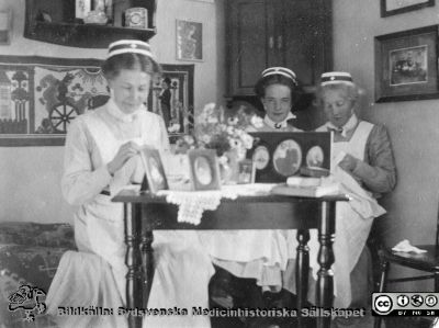 Tre sjuksköterskor med mössa från SSSH men utan hakband
Bild 41 i husmor Anna Landelius (1880-1964) efterlämnade fotoalbum. Ingrid Frennhoff (f. 1944) hade övertagit detta album efter sin morfar som i sin tur tagit hand om det efter sin syster husmor Anna på Lasarettet i Lund. Detta album är en gåva från Ingrid Frennoff till Sydsvenska Medicinhistoriska Sällskapet nyåret 2020.
De handarbetar i ett bostadsrum. Sköterskebrosch syns bara på två.
Nyckelord: Sjuksköterskor;SSSH;Bostadsrum;Handarbete