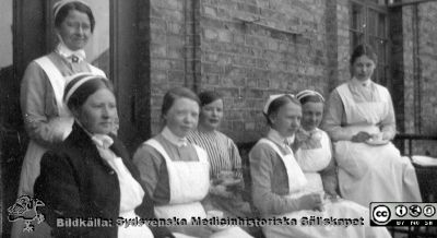 Kaffepaus med sköterskor och kanske en patient på en balkong. 
Bild 068-2 i husmor Anna Landelius (1880-1964) efterlämnade fotoalbum. Ingrid Frennhoff (f. 1944) hade övertagit detta album efter sin morfar som i sin tur tagit hand om det efter sin syster husmor Anna på Lasarettet i Lund. Detta album är en gåva från Ingrid Frennhoff till Sydsvenska Medicinhistoriska Sällskapet nyåret 2020.
Flera är SSSH-sköterskor. Nr 2 från höger är nog Anna Landelius. Foto möjligen på kirurgiska kliniken i Lund på 1920-talet.
Nyckelord: SSSH;Sjuksköterskor;Kaffepaus;Balkong