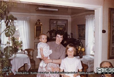 Smålandssläktingar till Augusta Persson
Foto i John och Augusta Perssons stiftelses arkiv. Bilden visar släktingar till Augusta.  
Den unga kvinnan är enligt Katarina Ek-Nilsson Sven-Åke Isaksons hustru Lena och babyn är deras gemensamma. Hon vet inte vad babyn heter, men flickan i bilden heter Elisabeth och Katarina Ek-Nilsson är osäker på om hon föddes i Sven-Åkes första eller andra äktenskap. I kanten syns Katarina Ek-Nilssons mormor Anna Andersson i soffan (gift Pearson i USA, änka och omgift). Foto hos Signe och Anton Isakson i Hökhult. Okänd fotograf.
Nyckelord: Miljonärer;Donatorer;IBM;Skärgård;JAP;John och Augusta Perssons stiftelse;Medicinska fakulteten;Lunds universitet