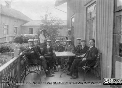 Erik M. P. Widmark i en grupp studenter.
Bilden saknar märkning. Erik Widmark sitter som nr 2 från  vänster enligt bildkällan, barnbarnet Eva Marie Widmark.Foto rimligen på 1910-talet.  Fotograf okänd.
Nyckelord: Studenter;Veranda