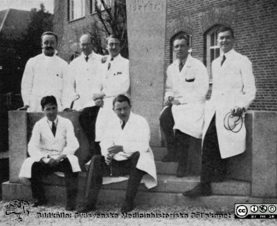 Erik Ask-Upmark i grupp framför medicinska kliniken i Lund.
Grupp kring foten av Karl Petréns byst utanför medicinska kliniken i LUnd. Rimligen på 1930-talet. Erik Ask-Upmark längst till vänster i bakre ledet. Sittande framför honom kollegorna Birger Herner och Curt Wallman-Carlsson. Från Ask-Us autobiografi 1969.
Nyckelord: Medicinsk fakultet;Medicinska kliniken i Lund;Medicinska kliniken i uppsala.;Läkare