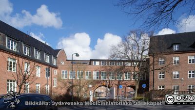 SUS i Lund. Klinikerna runt Helgonabacken. Foto 2020-03-22.
SUS i Lund. Klinikerna runt Helgonabacken. Till vänster hudhuset (ursprungligen internmedicinsk klinik, byggd 1918), valvbågen över till reumatologiska kliniken och reumatologiska kliniken (byggd 1928).
Nyckelord: Intern Medicinsk;Klinik;Reumatologisk klinik;Vallvbåge