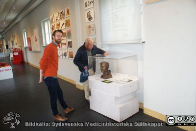 Kulturens intendent Mats Engström har just arrangerat montern om Erik M. P. Widmark på Livets Museum i Lund
Kulturens intendent Mats Engström har just arrangerat montern om Erik M. P. Widmark nära ingången till Livets Museum i Lund den 29 april 2020. Anders Biörklund beskådar monterns innehåll.
Nyckelord: Byst;Skulptur;Medicinsk kemi;Medicinska fakulteten;Universitetet i Lund;Livets Museum