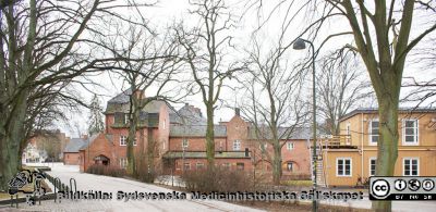 Universitetssjukhuset SUS Lund, 2012.  1918 års ovanjordiska kulvert  med valvtorn och restaurang Valvet. Barack med telefonväxel och expeditioner för externa byggfirmor.
Universitetssjukhuset SUS Lund, mars 2012. Sydöstra delen av 1918 års ovanjordiska kulvert mellan södra och norra lasarettsområdet med valvtorn och restaurang Valvet. Hitom den tvåvånings barack som hyser telefonväxeln och expeditioner för externa byggfirmor mm. Med lite god vilja skulle man här kunna anlägga en tilltalande park som skulle passa väl ihop med den mellan UB, Skissernas Museum och Biskopshuset.
Nyckelord: Universitetssjukhuset SUS Lund;USiL;Kulvert;Administration;Telefonväxel;Valvet;Restaurang.