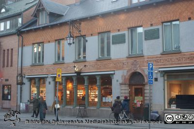 Den nyrenoverade gyllene svanen på universitetsapotekets nyrenoverade fasad på Kyrkogatan i Lund tillsammans med det gamla cykelstället och fasadlyktan ovanför
Den nyrenoverade gyllene svanen på universitetsapotekets nyrenoverade fasad på Kyrkogatan i Lund tillsammans med det gamla cykelstället och fasadlyktan ovanför. Foto Berndt Ehinger
Nyckelord: Universitetsapotek;Svanen;Lund;Fasad;Nyrenoverad