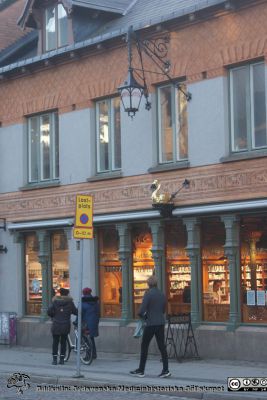 Den nyrenoverade gyllene Svanen på universitetsapoteket Svanens nyrenoverade fasad tillsammans med det gamla cykelstället och fasadlyktan ovanför. Foto Berndt Ehinger
Nyckelord: Universitetsapotek;Svanen;Lund;Fasad;Nyrenoverad