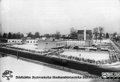 Vårdcentralen i Dalby i vinterskrud
Vårdcentralen i Dalby i vinterskrud, Flygfoto. Informatiion 200204 från P-O Bitzén aom arbetade på vårdcentalen: Foto 4 febr 1972 av fotograf Knut Andreassen i  Lund. Vårdcentralen byggdes 1967 och invigdes 1 febr 1968. Tegelbyggnaden bakom vita skorstenen är Östra skolan. Den byggdes 1912 men revs år1972 för att ge plats åt bostäder för äldreboende. Bakom skolan ligger det då nybyggda ålderdomshemmet Hällbodal, numera också rivet. Bildkälla Håkan Westling-arkivet på UB i Lund.
Nyckelord: Vårdcentral;Flerläkarstation;Allmänläkare;Flygfoto;Skola;ldreboende