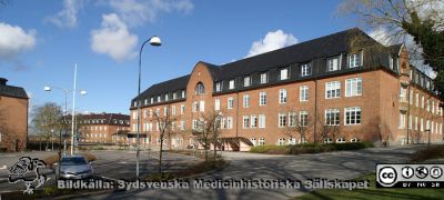 Hudhuset på Universitetssjukhuset SUS i Lund
Hudhuset på Universitetssjukhuset SUS i Lund (ursprungligen internmedicinsk klinik, klar 1918). Fasad mot söder. Längst till vänster Kvinnokliniken, också den byggd 1918 med senare tillbyggnader, nu Rehabhus och olika administrationskontor.
Nyckelord: Medicinsk klinik;Internmedicinsk;Hud;Dermatologisk;SSSH;Sjuksköterskeskola;Rehabilitering.