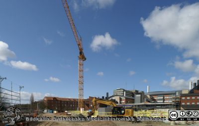 Forum Medicum har just börjat byggas, våren 2021
Forum Medicum har just börjat byggas på tomten mellan gamla vattentornet i Lund och Biomedicinskt Centrum (BMC). I fonden  Biomedicinskt Centrum (BMC) från slutet av 1900-talet. Till vänster Wigerthuset (gamla psykiatriska kliniken). C-blocket från 1968 på Universitetssjukhuset i Lund sticker upp i bakgrunden. Foto från Sölvegatan 2021-04-10 genom en av de stora grindarna till arbetsplatsen.
Nyckelord: USiL;Lasarettet i Lund;Medicinska fakulteten;Lunds universitet;Bygge;Sölvegatan;Psykiatrisk klinik