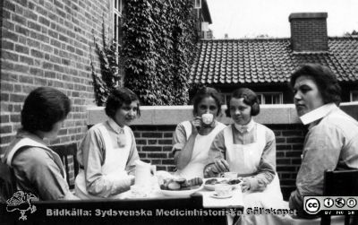 Vårdpersonal tar kaffepaus 
Vårdpersonal tar kaffepaus på en balkong vid östra fasaden på röntgenologibyggnaden på Lasarettet i Lund i södra området (kvarteret Paradis). Foto innan röntgenhuset byggs ut åt öster. Från Syster Elinas fotoalbum (Elina Holmberg?).
Nyckelord: Administration;Röntgenologi;Lasarettet i Lund;Kaffepaus