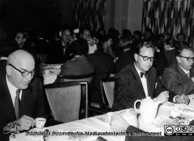 Kaffekalas med lasarettsdirektör Arne Johansson näst längst till höger på det närmaste bordet. 
Lokalen är osäker. Möjligen är det i den nya sjukhusmatsalen i början på 1960-talet. Från Syster Elinas fotoalbum (Elina Holmberg?) .
Nyckelord: Fest;Kaffekalas;Lasarettet i Lund