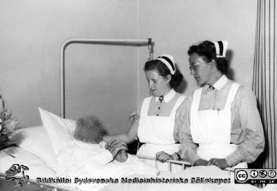 Sängliggande patient på radiologiska kliniken i Lund. 
Två SSSH-sjuksköterskor vid en sängliggande patient på radiologiska kliniken i Lund. Från Syster Elinas fotoalbum (Elina Holmberg?), troligen taget på 1950-talet.
Nyckelord: Radiologisk;Klinik;Lasarettet i Lund
