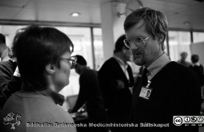 Forskningens Dag i Lund 1985
Lasarettsfotograferna i Lund,  pärm  Sv/v Negativ, 1985. 3. 81/85. Forskningens dag. Ingenjör Lars-Göran Angantyr talar med en besökare i en paus under mötet. Från negativ
Nyckelord: Lasarettet;Lund;Universitetssjukhuset;USiL;Forskningens Dag;Ortopedi;Höftleder;Symposium;Konferens;Möte