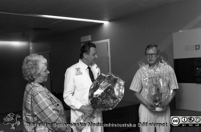 Jan Kugelberg uppvaktas
SMHS15600	Lasarettsfotograferna i Lund.  Blandade negativ, omärkta år 1988-1995 (lösa negativhållare). Thoraxkirurgen och klinikchefen, docent (slutligen professor) Jan Kugelberg uppvaktas av till vänster sjukhusdirektör Ulla Leissner och till höger Benny Jönsson i sjukhusdirektionen. Foto 91-06-27. Från negativ.
Nyckelord: Lasarettet;Lund;Universitetssjukhuset;USiL;Thorax;Kirurgi;Uppvaktning