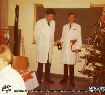 Julfest med avdelningen för klinisk fysiologi i Lund
Professor Håkan Westling tycks just ha avtackat en kollega, möjligen Ivar Nordenfelt. Foto c:a 1974. Ur undersköterskan Gunhild v(f. 1913-01-30) efterlämnade fotoalbum, överlämnat 2010 till SMHS.
Nyckelord: Lasarettet;Lund;Universitetssjukhuset;USiL;Personalfest;Avdelningen;Klinisk;Fysiologi