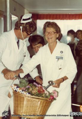 60-årsuppvaktning på avdelningen för klinisk fysiologi i Lund 1976
Den lätt förklädde professor Håkan Westling överräcker den cykel som blev 60-årspresent till SSSH-skötrskan Elin Höglund på avdelningen för klinisk fysiologi i Lund. Foto 1976. Ur undersköterskan Gunhild Wramhagens (f. 1913-01-30) efterlämnade fotoalbum, överlämnat 2010 till SMHS.
Nyckelord: Lasarettet;Lund;Universitetssjukhuset;USiL;Uppvaktning;Avdelningen;Klinisk;Fysiologi