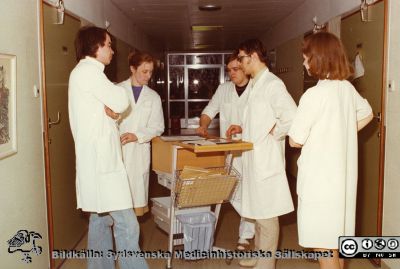 Rond på infektionskliniken i Lund ~1975
Foto ur album tillägnat professor Karl Emil Thulin på hans 60-årsdag, 1975. Infektionsläkarna Gunnar Kahlmeter och Ingrid Atterholm tillsammans med studenter och en sköterska i avdelningskorridoren på rond på avdelningen på infektionskliniken i Lund.
Nyckelord: Lasarettet;Lund;Universitetssjukhuset;USiL;Infektion;Kliniken;Epidemiologiska