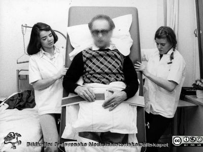 Rehabilitering av patient med tippbrits
Album till Karl Emil Thulins 60-årsdag, 1975. Patient på tippbrits, troligen tillsammans med två sjukgymnaster. Patienten har troligast en grav pares, och rehabilitering pågår rimligen.
Nyckelord: lLasarettet;Lund;Universitetssjukhuset;USiL;Epidemiologisk;Klinik;Infektion;Rehabilitering