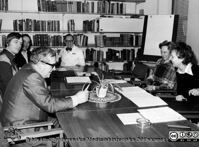 Sammanträde på biblioteket på infektionskliniken i Lund c:a 1974 - 1975
Album till Karl Emil Thulins 60-årsdag, 1975. Möjligen avdelningschefen på försörjningsavdelningen, intendent Bengt Lundquist närmast kameran, bortom honom ortopeden Svante Holgersson  (senare med efternamnet Ebbinghaus), sedan docent Carl Kamme, och professor Karl-Emil Thulin. De båda kvinnorna till höger ser ut att ha någon adminisdtrativ funktion, men är ine identifierade.
Nyckelord: Lasarettet;Lund;Universitetssjukhuset;USiL;Infektion;Kliniken;Sammanträde