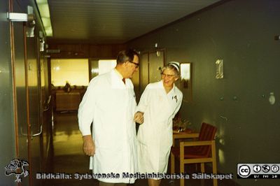 Professor Gösta Jönsson och avdelningsföreståndare Marta Ängeby
Professor Gösta Jönsson går rond tillsammans med avdelningsföreståndaren Marta Ängeby på urologiska avdelningen 22 nära 1970 och senast 1971 då S. Marta  pensionerades. Bildkälla: Eva Ljunggren.
Nyckelord: Lasarettet;Lund;Universitetssjukhuset;USiL;Urologiska;Kliniken