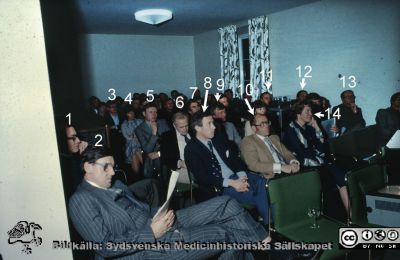 Kirurgmöte på Locus Medicus med kirurgprofessorn Ragnar Romanus och hans medarbetare i Göteborg, 1970 eller 1971
Omärkt diabild. Från vänster 1. Sten Eriksson, 2. Stig Bengmark, 3. Roland Andersson (långt i bakgrunden), 4. Birgitta Arneklo-Nobin, 5. Mats Ericsson med hand på hakan. 6. Ingemar Ihse. 7. Bengt Kallum. 8. Jan Oscarsson, 9. Bo Eklöf, 10. Lars-Olof Hafström, 11. Stig Ingemansson. 12. Bo Arnesjö. 13. Kanske Sten Tibblin? i bakgrunden intill väggen. 14. Britt Marie Toregard.
Nyckelord: Lasarettet;Lund;Universitetssjukhuset;USiL;Kirurgiska;Kliniken;Konferens;Seminarium