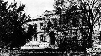 Barnbördshuset av år 1882. 
Tillbyggt med en våning och anslutet till röntgenklinikens byggnad med ett särskilt tornliknande hus tjänstgjorde det sedan först som personalbostad, sedan som expeditions- och laboratorielokal för röntgeninstitutet och åt kuratorer. Publicerad i Flaum 1968, sid. 161. Originalfoto, monterat
Nyckelord: Kapsel 17;Lund;Lasarett;Södra;Området;KK;Obstetrik;Röntgen;Socialmedicin