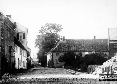 Bredgatan, (Kyrkogatan) med Härbärget och norr därom Munckska tomten. 
Foto av B.A. Lindgren från 1870-talet. Byggnadsnämnden, Lund. Publicerad i Flaum 1968, sid.73. Reprofoto, monterat.
Nyckelord: Kapsel 17;Lund;Gatubild