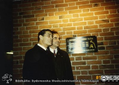 Professor Göran Bauer och docent (senare professor) Lars Lidgren vid den plakett som sattes upp vid ortopediska klinikens 75.årsjubileum.
Från ortoped klin album 01, Lund. Fotograf Berit Jakobsson.  1989. Professor Göran Bauer och docent (senare professor) Lars Lidgren vid den plakett som sattes upp vid klinikens 75.årsjubileum. Klinikchefer / professorer under dessa år var Gunnar Frsing, Gunnar Wiberg och Göran Bauer. På plaketten syns en höftprotes och en fotled. Själva huset tillkom 1929.
Nyckelord: Lund;Lasarett;Universitetssjukhus;USiL;Minnestavla;Ortopediska;Kliniker