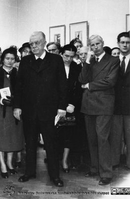 Ett socialt evenemang i LUnd
Brun ringbunden mjuk pärm, kirurgiska kliniken i Lund. Ett socialt evenemang i Lund nära 1950. Kanske vernissage på en konstutställning om Carl Fredrik Hill i Lund? Mitt i bilden står professorn i kirurgi, Gustav Petrén, bredbent. På hans högra sida står en kvinna med blygt nedslagen blick med ett blad i handen med ett tecknat porträtt på, kanske Carl Fredrik Hills självporträtt?. Till höger står Petréns efterträdare, professor Philip Sandblom, och på hans högra sida hans hustru Grace. Tavlorna i bakgrunden skulle kanske kunna varra gjorda av Carl Fredrik Hill? Bildkälla: Kirurgiska kliniken i Lund. Odriginalfoto, monterat.
Nyckelord: Utställning;Lund;Kirurgiska;Kliniken