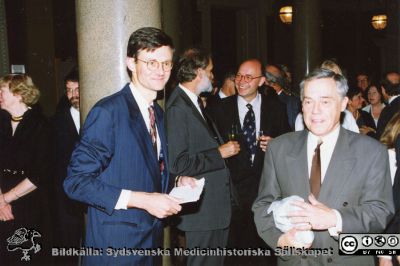 Philip Sandblom-symposium 1993 i Lund
Mingel i Universitetets aula inför symposiebankett i Pelarsalen. Docent Christian Ingvar (kirurg) och professor Nils Jonsson (patolog) närmast kameran.	Foto.
Nyckelord: Lasarettet;Lund;Universitetssjukhuset;USiL;Kirurgiska;Kliniken;Symposium;Möte;Fest;Bankett