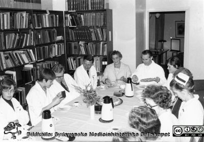 Kaffepaus i biblioteket på hudkliniken i Lund på 1960-talet
Från docent Sigfrid Fregerts bildsamling från hud- och könskliniken i Lund och från yrkesdermatologin i Lund. Vid kortänden professor Gösta Hagerman (1907-1902). På hans högra sida hudläkren Ella Grubb (1918-1990) och invid henne hudläkren Niels Bang Pedersen, hudläkaren Arnar Thorgilsson. kanske hudläkaren Ingrid Thelin och längst till vänster hudläkaren Eva Tegner. Kvinnorna på Hagermans vänstra sida är okända. Foto.
Nyckelord: Lasarettet;Lund;Universitetssjukhuset;USiL;Hud- och könsklinik;Hud;Klinik;Dermatologisk;Venerologisk