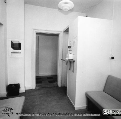 Ett polikliniskt väntrum på hudkliniken i Lund nära 1970
Ur yrkesdermatologen Sigfrid Fregerts bildsamling från hud- och könskliniken i Lund och från yrkesdermatologiska avdelningen i Lund. Ett väntrum på våning 1 på hudkliniken i Lund. Det är oklart vad avbalkningen i bakgrunden till höger hade för funktion. Anmälningsluckan kan kanske ha varit avskärmad bakom? Foto rimligen nära 1970 inför klinikens avflyttning till Norra Lasarettsområdet. Foto.
Nyckelord: Lasarettet;Lund;Universitetssjukhuset;USiL;Hud- och könsklinik;Dermatologisk;Venerologisk
