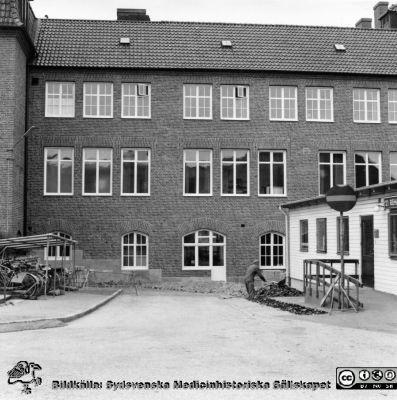 Nordfasaden på det nyrenoverade Hudhuset med det fönster som bild SMHS_LA2016-393 togs genom
Ur yrkesdermatologen Sigfrid Fregerts bildsamling från hud- och könskliniken i Lund och från yrkesdermatologiska avdelningen i Lund. Nordfasaden på det nyrenoverade Hudhuset med det fönster som bild SMHS_LA2016-393 togs genom. Till höger en barack med rehabiliteringsklinik och ortopedteknisk verkstad. Den brann i slutet på 1900-talet. Foto i mitten på 1970-talet. Från originalfoto.
Nyckelord: Lasarettet;Lund;Universitetssjukhuset;USiL;Hud- och könsklinik;Hud;Klinik;Dermatologisk;Venerologisk;Avdelning
