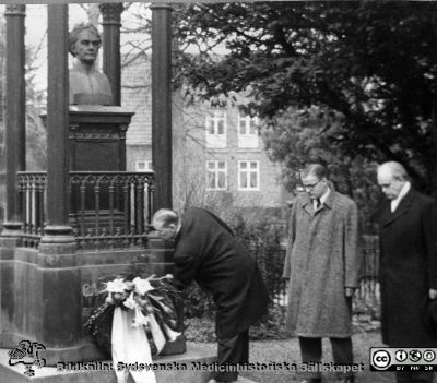 Akademiska Föreningens 125-årsdag  1/12 1955
AF:s ordförande, professor K.G. Ljunggren lägger AF:s krans  på C.A. Agardhs grav på Östra kyrkogården i Lund. Närmast Ljunggren står Olof Ruin, Studentkårens ordförande 1955. Till höger A.F:s dåvarande kassör, docent Martin Weibull.
Nyckelord: Jubileum;Kransnedläggning;Akademiska Föreningen i Lund;Lunds universitet;Kyrkogård