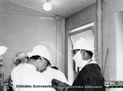 Göran Eklundh och Carl-Otto Fogelberg på thoraxklinikens laboratorium på fysiologiska institutionen i Lund c:a 1961 
Göran Eklundh (till vänster i bild) på thoraxklinikens laboratorium på fysiologiska institutionen i Lund c:a 1961 där man gjorde försök med hjärtlungmaskin på hundar, bl.a. med tester av klaffproteser och studier av ventrikelflimmer och defibrillering. Till höger dr. Carl-Otto Fogelberg, senare narkosläkare. Bildkälla Carsten Lührs.
Nyckelord: Lasarettet;Lund;Universitetssjukhuset;USiL;Thorax;Kirurgiska;Kliniken;Institutionen;Fysiologiska