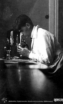 Fotoalbum märkt Histologikursen Ht. -27 på första bladet.
Fotoalbum märkt Histologikursen Ht. -27 på första bladet. Det innehåller bilder från dåvarande histologiska avdelningen 
på anatomiska institutionen i Lund på Biskopsgatan 7. Bildtext saknas, men bilden visar emn ung man vid ett mikroskop på kurslaboratoriet, kanske en amanuens eller lärare. .
Bildkälla Stiftelsen Locus Medicus Lundensis 250317. Fotograf okänd.
Nyckelord: Histologiska avdelningen;Anatomiska Institutionen;Medicinska fakulteten i Lund;Locus Medicus Lundensis;Universitet;Studenter