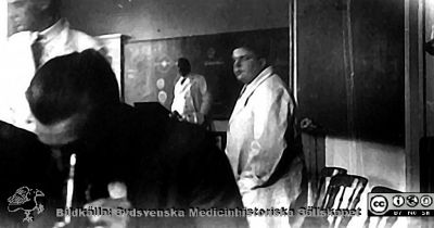 Fotoalbum märkt Histologikursen Ht. -27 på första bladet.
Fotoalbum märkt Histologikursen Ht. -27 på första bladet. Det innehåller bilder från dåvarande histologiska avdelningen 
på anatomiska institutionen i Lund på Biskopsgatan 7. Bildtext "Föreläsningarna", men saknas i övrigt. Bilden visar studenter vid mikroskop på kurslaboratoriet och lärare i vita rockar. Kanske är det professor Torsten Hellman vid svarta tavlan och två amanuenser .
Bildkälla Stiftelsen Locus Medicus Lundensis 250317. Fotograf okänd.
Nyckelord: Medicine studerande;Kurslaboratorium;Medicinska fakulteten i Lund;Universitet;Locus Medicus Lundensis