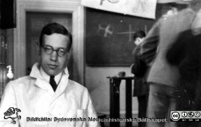 Foton från histologkursen i Lund 1929. 
Fotoalbum tillägnat Professor Torsten Hellman med tacksamhet och vördnad från histologkursen 1929. Bildtext "Olof Ask". 
Rimligen en yngre lärare på avdelningen. Foto i föreläsningssalen.
Nyckelord: Anatomiska Institutionen;Histologiska avdelningen;Mikroskopering;Medicinska fakulteten i Lund;Locus Medicus Lundensis;Universitet