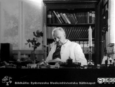 Bild i fotoalbum  tillägnat professor Torsten Hellman från deltagarna i histologikursen ht 1930. 
Fotoalbum  "TILL PROFESSOR TORSTEN hELLMAN MED TACK FRÅN DELTAGARNA I HISTOLOGIKURSEN HÖSTTERMINEN 1930".  Bildtext "cHEFEN ".  Bilden visar professor Torsten Hellman vid sitt skrivbord. Bildkälla stifteleen Locus Medicus Lundensis och Sydsvenska Medicinhistoriska Sällskapet / SMHS. Fotograf okänd.
Nyckelord: Histologiska avdelningen;Anatomiska Institutionen;Medicinska fakulteten i Lund;Sydsvenska Medicinhistoriska Sällskapet;Locus Medicus Lundensis;Lärare;Skrivbord