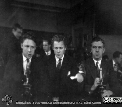 Bild i fotoalbum  tillägnat professor Torsten Hellman från deltagarna i histologikursen ht 1930. 
Fotoalbum  "TILL PROFESSOR TORSTEN hELLMAN MED TACK FRÅN DELTAGARNA I HISTOLOGIKURSEN HÖSTTERMINEN 1930".  Bildtext "Olausson, Holmdahl, M. Larsson". Foto troligen i mirkoskoperingssalen.
Bildkälla stiftelsen Locus Medicus Lundensis och Sydsvenska Medicinhistoriska Sällskapet / SMHS. Fotograf okänd.
Nyckelord: Histologiska avdelningen;Anatomiska Institutionen;Entrétrappa;Medicinska fakulteten i Lund;Sydsvenska Medicinhistoriska Sällskapet;Locus Medicus Lundensis;Eleve