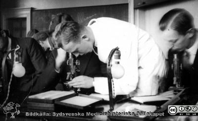 Fotoalbum "Kursen i histologi H T 1932.
Fotoalbum "Kursen i histologi H T 1932". Bildtext "Chefen. Blivande e o har redan börjat som...".  Troligen en blivande e o i aktion vid ett kursmikroskop på histologiska avdelningens mkroskoperingssal på anatomiska institutionen i Lund. 
Bildkälla stiftelsen Locus Medicus Lundensis och Sydsvenska Medicinhistoriska Sällskapet / SMHS. Fotograf okänd.
Nyckelord: Medicine studerande;Histologiska avdelningen;Anatomiska Institutionen;Medicinska fakulteten i Lund;Locus Medicus Lundensis;Universitetet i Lund