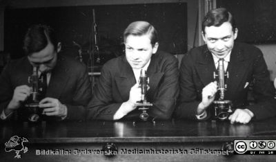 Fotoalbum "Kursen i histologi H T 1932.
Fotoalbum "Kursen i histologi H T 1932".  Bildtext: "Börje Olsson, Gülich, Ohlsén".  Troligen tre medicine studerande vid  kursmikroskop på histologiska avdelningens mikroskoperingssal på anatomiska institutionen i Lund. 
Bildkälla stiftelsen Locus Medicus Lundensis och Sydsvenska Medicinhistoriska Sällskapet / SMHS. Fotograf okänd.
Nyckelord: Medicine studerande;Histologiska avdelningen;Anatomiska Institutionen;Medicinska fakulteten i Lund;Locus Medicus Lundensis;Universitetet i Lund
