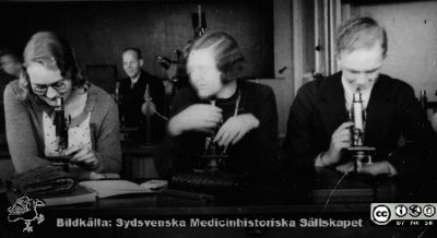 Fotoalbum "Kursen i histologi H T 1932.
Fotoalbum "Kursen i histologi H T 1932". Bildtext "Ehrenstam, Körner, Torsten Nilsson".  Troligen tre medicine studerande vid  kursmikroskop på histologiska avdelningens mikroskoperingssal på anatomiska institutionen i Lund. 
Bildkälla stiftelsen Locus Medicus Lundensis och Sydsvenska Medicinhistoriska Sällskapet / SMHS. Fotograf okänd.
Nyckelord: Medicine studerande;Histologiska avdelningen;Anatomiska Institutionen;Medicinska fakulteten i Lund;Locus Medicus Lundensis;Universitetet i Lund
