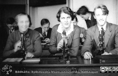 Fotoalbum "Kursen i histologi H T 1932.
Fotoalbum "Kursen i histologi H T 1932". Bildtext "Heijbel, Aurelius, Palm".  Maj Heijbel gifte sig med kurskamraten Sven Belfrage (1911-2009, överläkare på infektionskliniken i Malmö).  Troligen medicine studerande vid  kursmikroskop på histologiska avdelningens mikroskoperingssal på anatomiska institutionen i Lund. 
Bildkälla stiftelsen Locus Medicus Lundensis och Sydsvenska Medicinhistoriska Sällskapet / SMHS. Fotograf okänd.
Nyckelord: Medicine studerande;Histologiska avdelningen;Anatomiska Institutionen;Medicinska fakulteten i Lund;Locus Medicus Lundensis;Universitetet i Lund