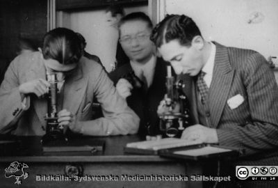 Fotoalbum "Kursen i histologi H T 1932.
Fotoalbum "Kursen i histologi H T 1932".  Bildtext "Lando (Londo?), Tor Larsson, Blecher". Troligen medicine studerande vid  kursmikroskop på histologiska avdelningens mikroskoperingssal på anatomiska institutionen i Lund. 
Bildkälla stiftelsen Locus Medicus Lundensis och Sydsvenska Medicinhistoriska Sällskapet / SMHS. Fotograf okänd.
Nyckelord: Medicine studerande;Histologiska avdelningen;Anatomiska Institutionen;Medicinska fakulteten i Lund;Locus Medicus Lundensis;Universitetet i Lund