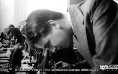 Fotoalbum "Kursen i histologi H T 1932.
Fotoalbum "Kursen i histologi H T 1932".  Bildtext "Herner".  Möjligen Birger Herner (1910 - 1999, lasarettsläkare i Varberg). Troligen medicine studerande vid  kursmikroskop på histologiska avdelningens mikroskoperingssal på anatomiska institutionen i Lund. 
Bildkälla stiftelsen Locus Medicus Lundensis och Sydsvenska Medicinhistoriska Sällskapet / SMHS. Fotograf okänd.
Nyckelord: Medicine studerande;Histologiska avdelningen;Anatomiska Institutionen;Medicinska fakulteten i Lund;Locus Medicus Lundensis;Universitetet i Lund