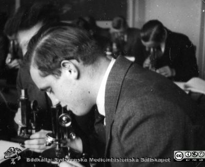 Fotoalbum "Kursen i histologi H T 1932.
Fotoalbum "Kursen i histologi H T 1932".  Bildtext "Berggren"". Troligen medicine studerande i histologiska avdelningens mikroskoperingssal på anatomiska institutionen i Lund. 
Bildkälla stiftelsen Locus Medicus Lundensis och Sydsvenska Medicinhistoriska Sällskapet / SMHS. Fotograf okänd.
Nyckelord: Medicine studerande;Histologiska avdelningen;Anatomiska Institutionen;Medicinska fakulteten i Lund;Locus Medicus Lundensis;Universitetet i Lund